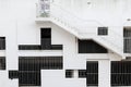 Abstract exterior architectural background - grille windows of different shapes and sizes at white concrete wall Royalty Free Stock Photo