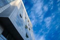 abstract facade of a modern contemporary finance business building with mirror windows, some of them being opened to let air Royalty Free Stock Photo