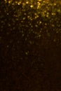 Abstract falling golden bokeh on brown background.