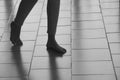 Abstract female feet go on tiled floor casting a shadows. The girl is walking barefoot on tile surface, blur in motion.