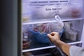 Abstract female hand of woman is opening a gray refrigerator door Royalty Free Stock Photo