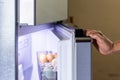 Abstract female hand of woman is opening a gray refrigerator door Royalty Free Stock Photo