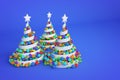 Abstract festive spiral christmas tree made of white ribbon with rainbow xmas balls. 3d render illustration on blue background. Royalty Free Stock Photo