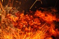 Trails of flame sparks. Burning traces glowing over black backdrop. Abstract fiery background. Orange color fire sparks closeup