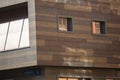 Abstract filled frame close up background wallpaper shot of a corner of a modern stylish brown wood planks wall with windows