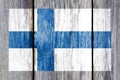 Grunge pattern of Finland national flag isolated on weathered wooden fence board.