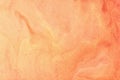 Abstract fluid art background coral colors. Liquid marble. Acrylic painting on canvas with orange shiny gradient