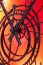 An abstract fragment of a decorative brass clockwork on a shiny red-orange background.