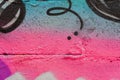 Abstract fragment of wall with detal of graffiti, old chipped paint, scratch, grunge texture. Aerosol design, pink-blue