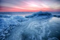 Abstract frozen winter sunrise seascape with ice and colored the sky. Royalty Free Stock Photo