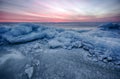 Abstract frozen winter sunrise seascape with ice and colored the sky. Royalty Free Stock Photo