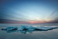 Abstract frozen winter sunrise seascape with ice and colored the sky. Royalty Free Stock Photo