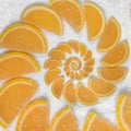 Abstract fruit slices jelly wedges orange cantle lobule on white sugar background. Orange sweet fruit segments. Juicy fruit