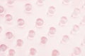 Abstract gentle pink background - transparent glass balls as pattern on pastel color, top view.