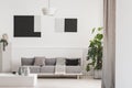 Abstract geometric black and grey paintings on white wall of trendy living room interior