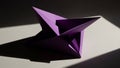 Abstract Geometric Purple Origami Star Sculpture with Sharp Edges and Deep Shadows Cast on a Light Surface Creating a Dramatic and Royalty Free Stock Photo
