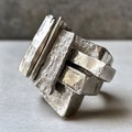 Abstract geometric silver ring with textured surface on neutral background Royalty Free Stock Photo
