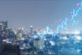 Abstract glowing upward candlestick forex chart on blurry city grid backdrop. Trade, finance and money concept. Royalty Free Stock Photo