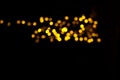 Abstract gold bokeh on black background. Defocused yellow lights, abstract texture Royalty Free Stock Photo