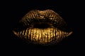 Abstract gold lips. Golden lips closeup. Gold metal art lip. Beautiful makeup. Golden lip gloss on beauty female mouth