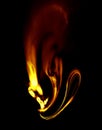 Abstract golden flaming element with twirls and smoke shines and smolders on black background. Royalty Free Stock Photo