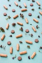 Abstract green background with capsules, pills and herbs. Alternative medicine. Vertical view