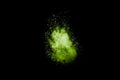 Abstract green dust explosion on black background. Green powder splattered