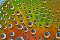 Abstract green and orange metallic surface with silver rainbow bubbles