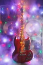 Abstract guitar with festive Christmas color lights and music speakers in smoke