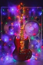 abstract guitar with festive Christmas lights and music speakers in smoke