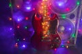 Abstract guitar with festive Christmas lights and music speakers in smoke