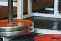 Abstract hardcore gym theme background with bright orange painted chapped old weight plates placed on a stand and floor around a Royalty Free Stock Photo