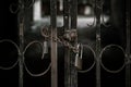 Abstract horror scary background, mysterious strange dark black rusty grunge iron gate with a metal chain with a lock