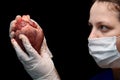 Abstract illegal organ transplantation. A human heart in the hand of a surgeon woman. International crime. Assassins in white coat