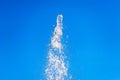 Abstract water fountain splash into clear blue sky.