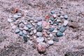 Abstract illustration of a heart made of stones at the sand. Royalty Free Stock Photo