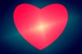 Red heart on a blue background. Bright ilumination in middle.