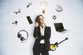 Abstract image of attractive thinking woman with idea head, laptop, guitar and other items flying around on white wall background