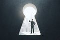 Abstract image of businessman standing in keyhole opening and looking into the distance on blurry city background. Vision, future Royalty Free Stock Photo