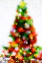 Abstract image of a colorful Christmas tree and lights of garlands on a white background. Royalty Free Stock Photo