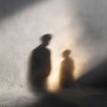 Abstract image featuring shadows of two figures on a textured wall. Evokes mystery, anonymity, relationships, or introspection. Royalty Free Stock Photo