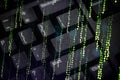 Abstract image of green matrix-style digital code over a black computer keyboard, representing cyber security, data encryption, Royalty Free Stock Photo