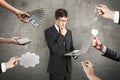 Abstract image of hands offering money, ideas, keys, lamps and devices to thoughtful young businessman with laptop in concrete Royalty Free Stock Photo