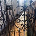 An abstract image of a narrow passageway behind locked gate