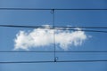 Abstract image, small white cloud in blue sky behind the straight strict lines of power and control cables Royalty Free Stock Photo