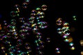 Abstract image of soap bubbles from the bubble blower in dark or black background. Royalty Free Stock Photo
