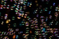 Abstract image of soap bubbles from the bubble blower in dark or black background. Royalty Free Stock Photo