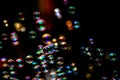 Abstract image of soap bubbles from the bubble blower in dark or black background. Royalty Free Stock Photo