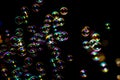 Soap bubbles from the bubble blower in dark or black background. Royalty Free Stock Photo