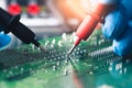 The abstract image of the technician using voltage meter for voltage measurement in computer mainboard.